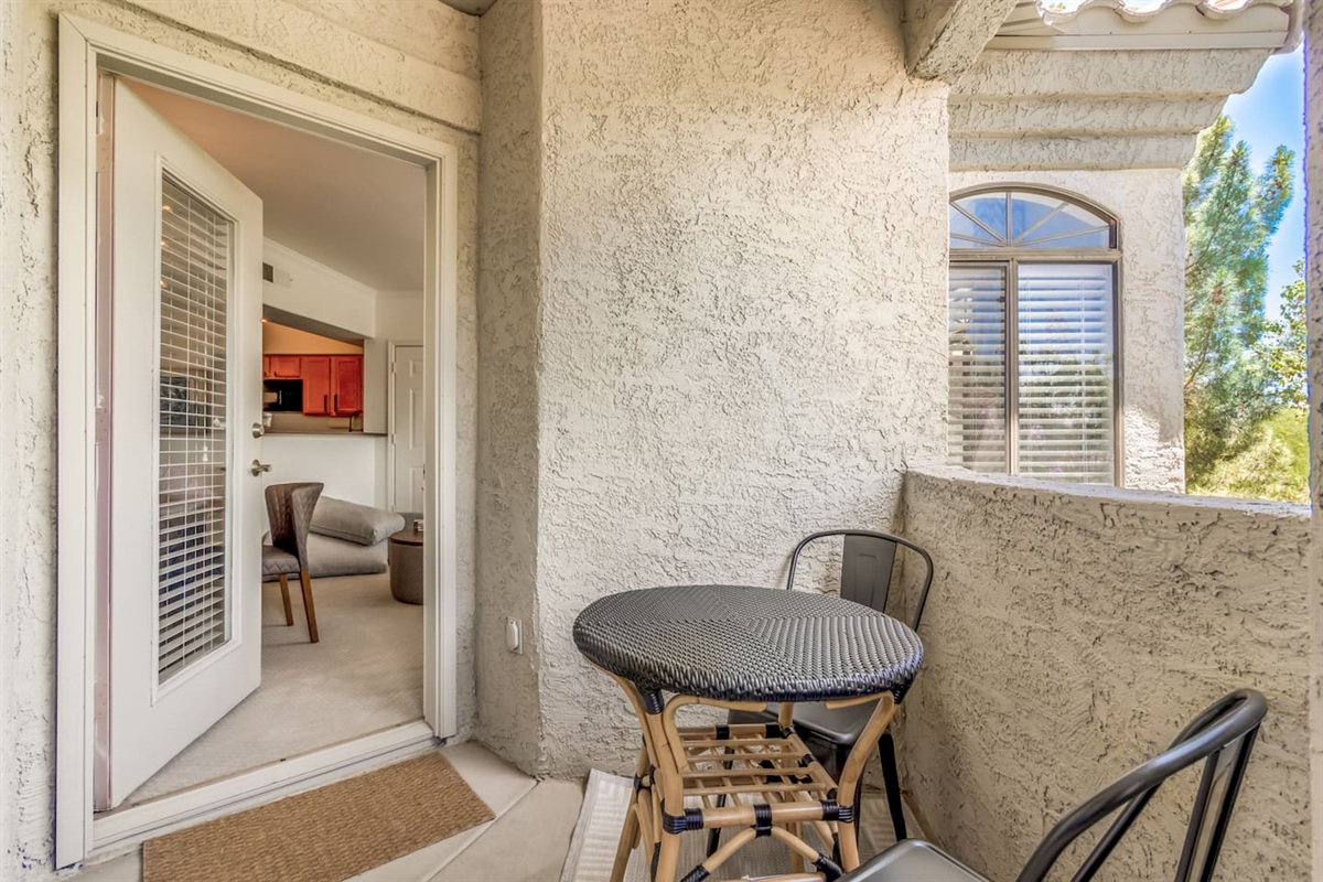 Outdoor balcony with chairs and a bistro table for a simple place to relax outside.