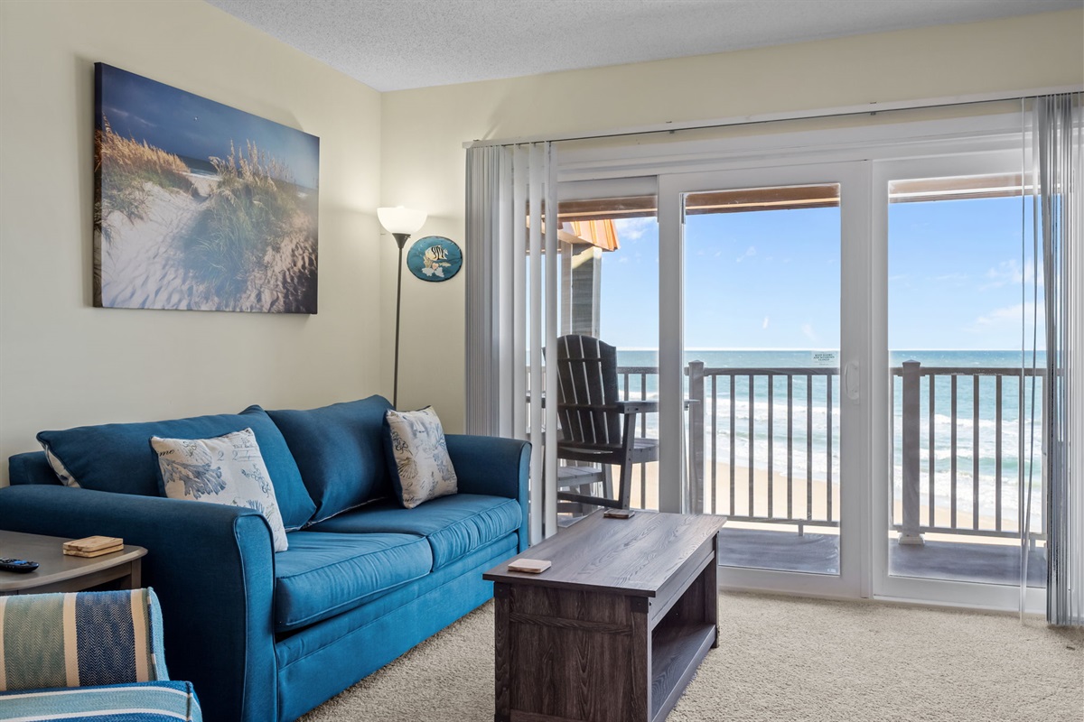 Bright, oceanfront living room with direct balcony access&mdash;relax on the sofa and enjoy uninterrupted views of the Atlantic just beyond the glass