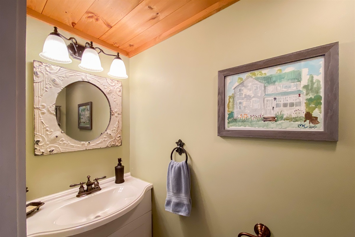 Upstairs half bath in the hall for the two other bedrooms, behind a pocket door.