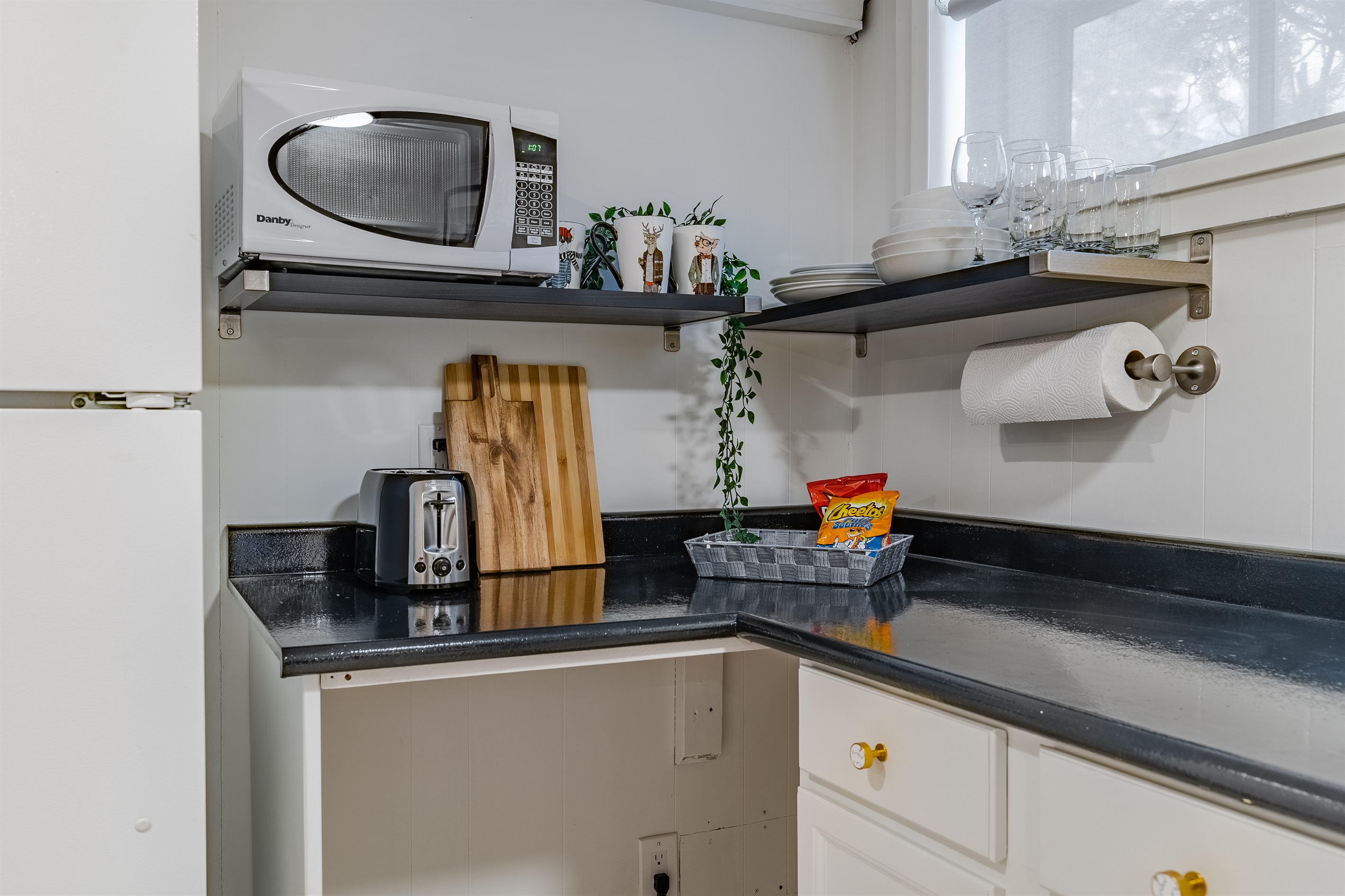 Compact prep space with microwave, toaster, kettle, and essentials for light meals and take-out.