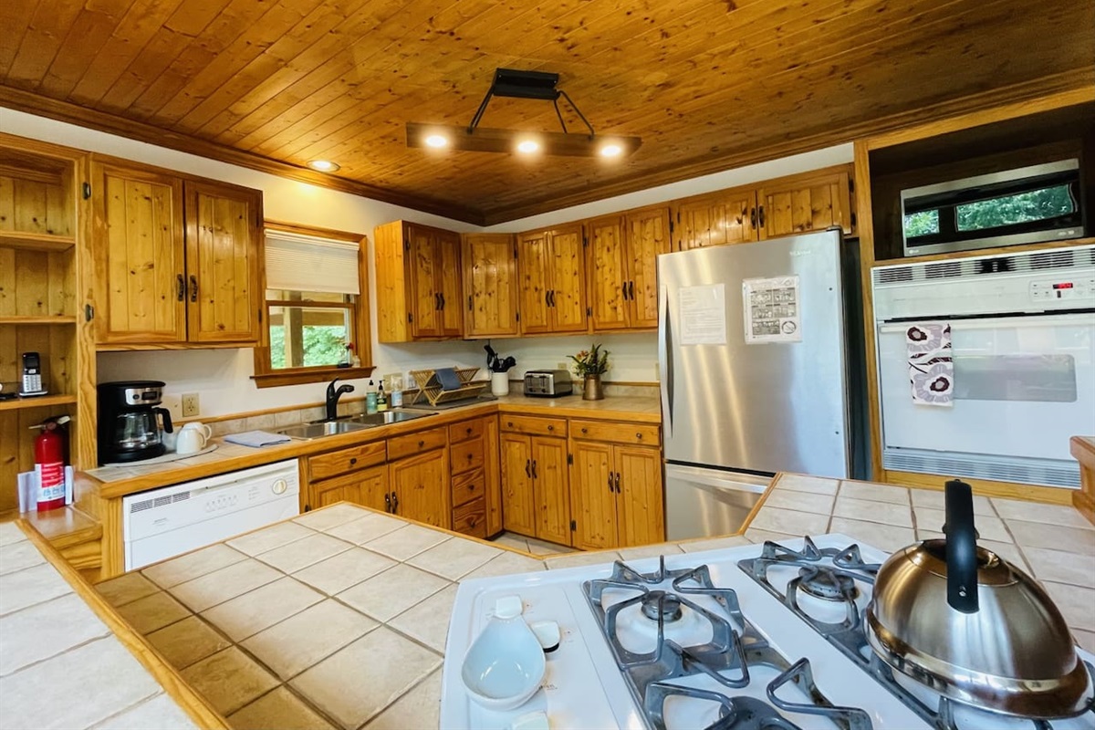 The kitchen has a propane cooktop with prep space, a wall oven, and everything else you could need. Super well stocked
