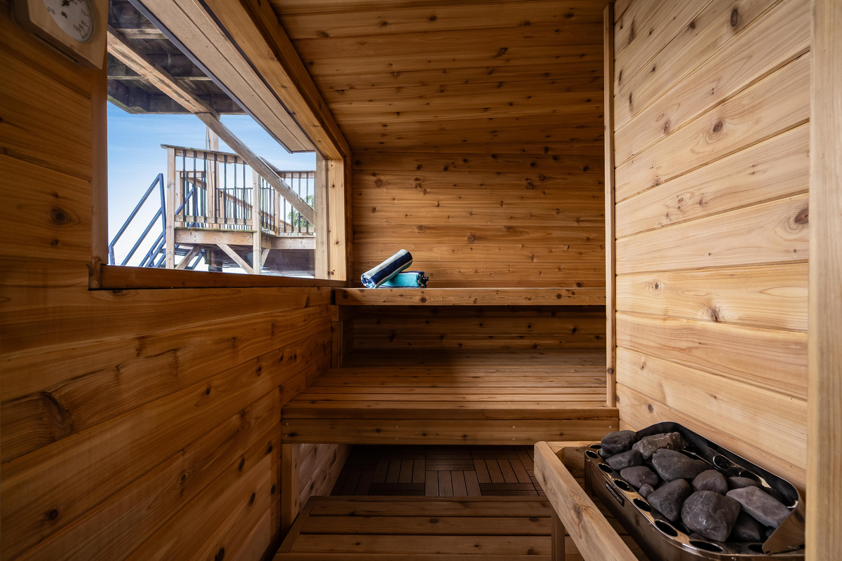 Traditional wood-lined sauna with a spacious bench and stone heater.