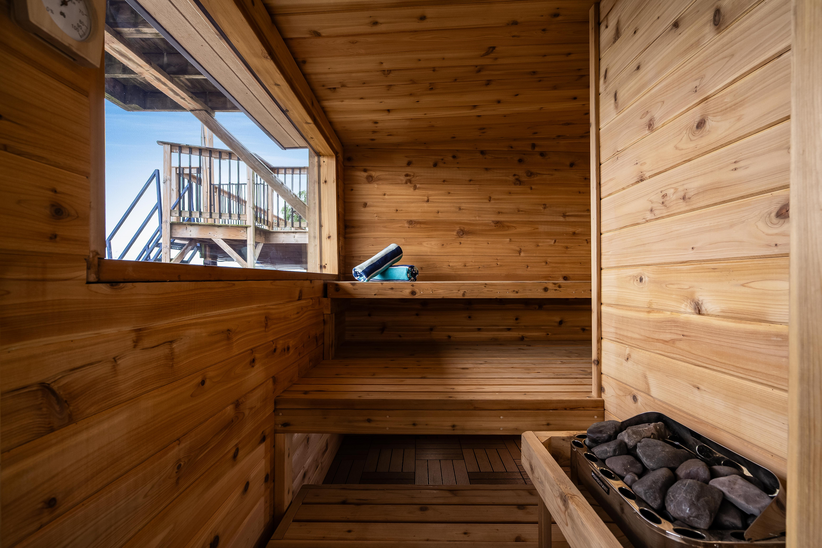 Traditional wood-lined sauna with a spacious bench and stone heater.