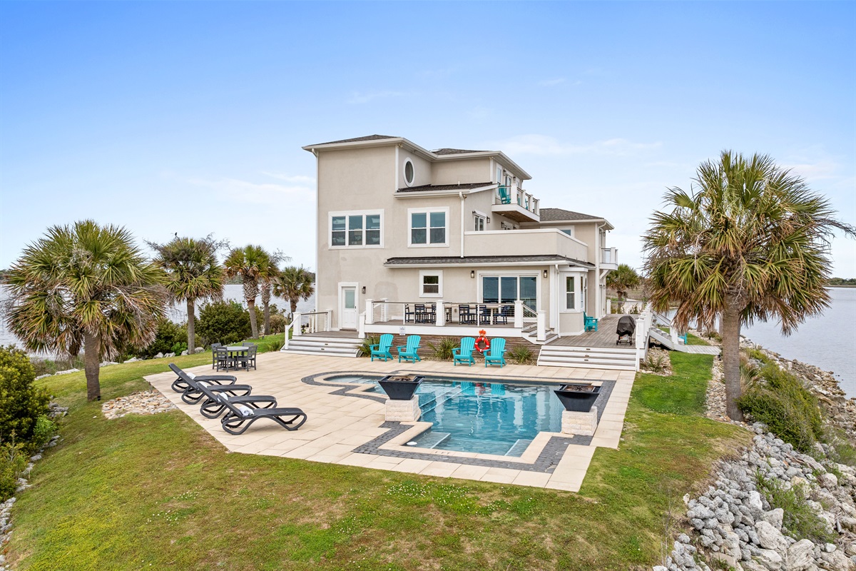 Expansive backyard oasis featuring a resort-style pool surrounded by panoramic water views