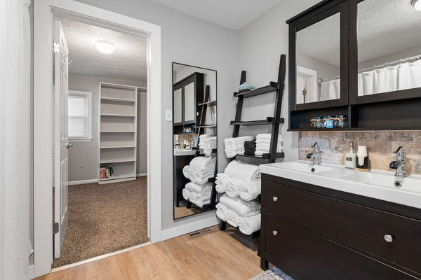 Private primary bathroom with a combination tub and shower, towels, and toiletries.