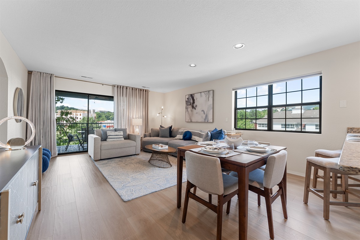 🛋 Spacious open-plan living and dining area with stylish midcentury accents, abundant light, and golf course views from the private deck.