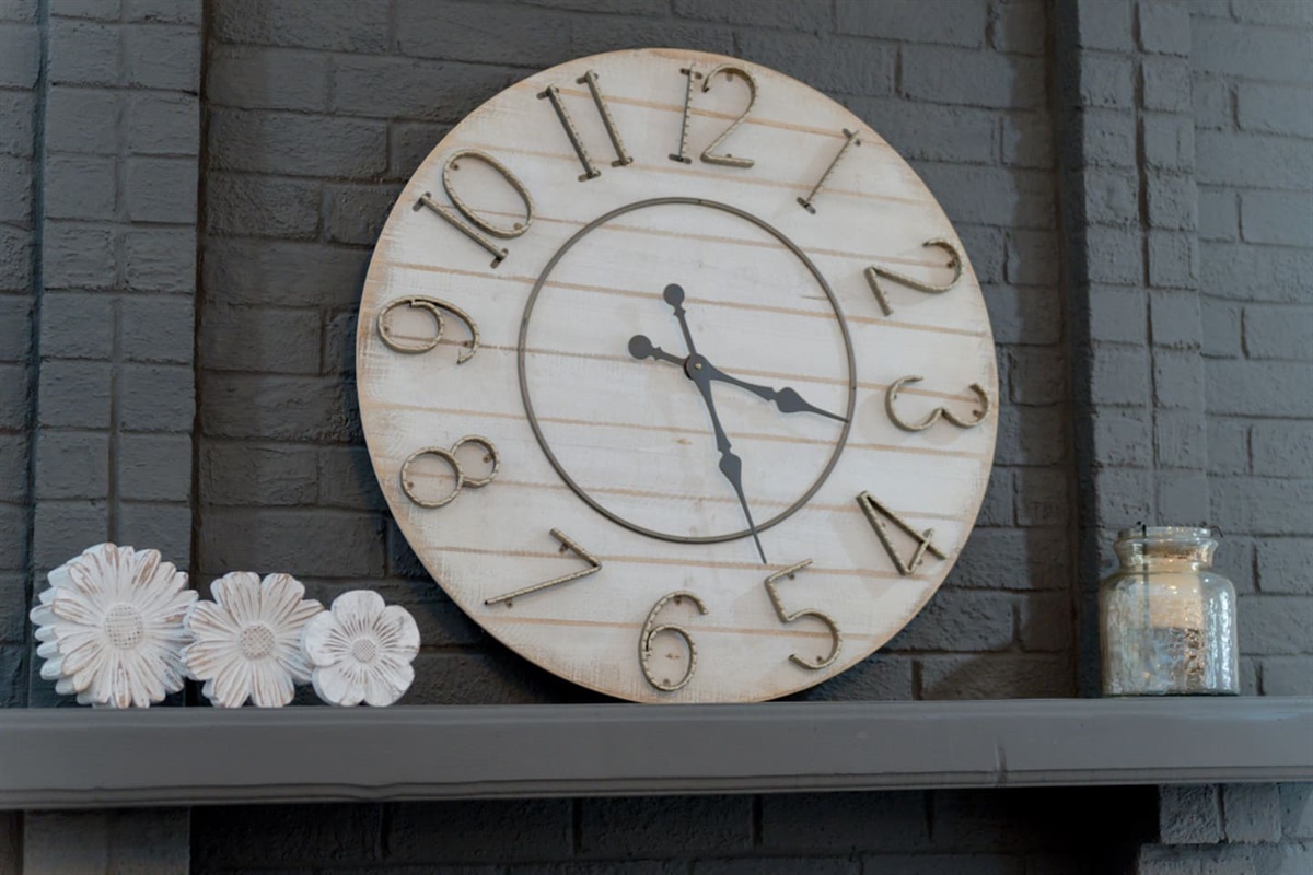 Decorative wall clock centerpiece over the fireplace for timeless charm.