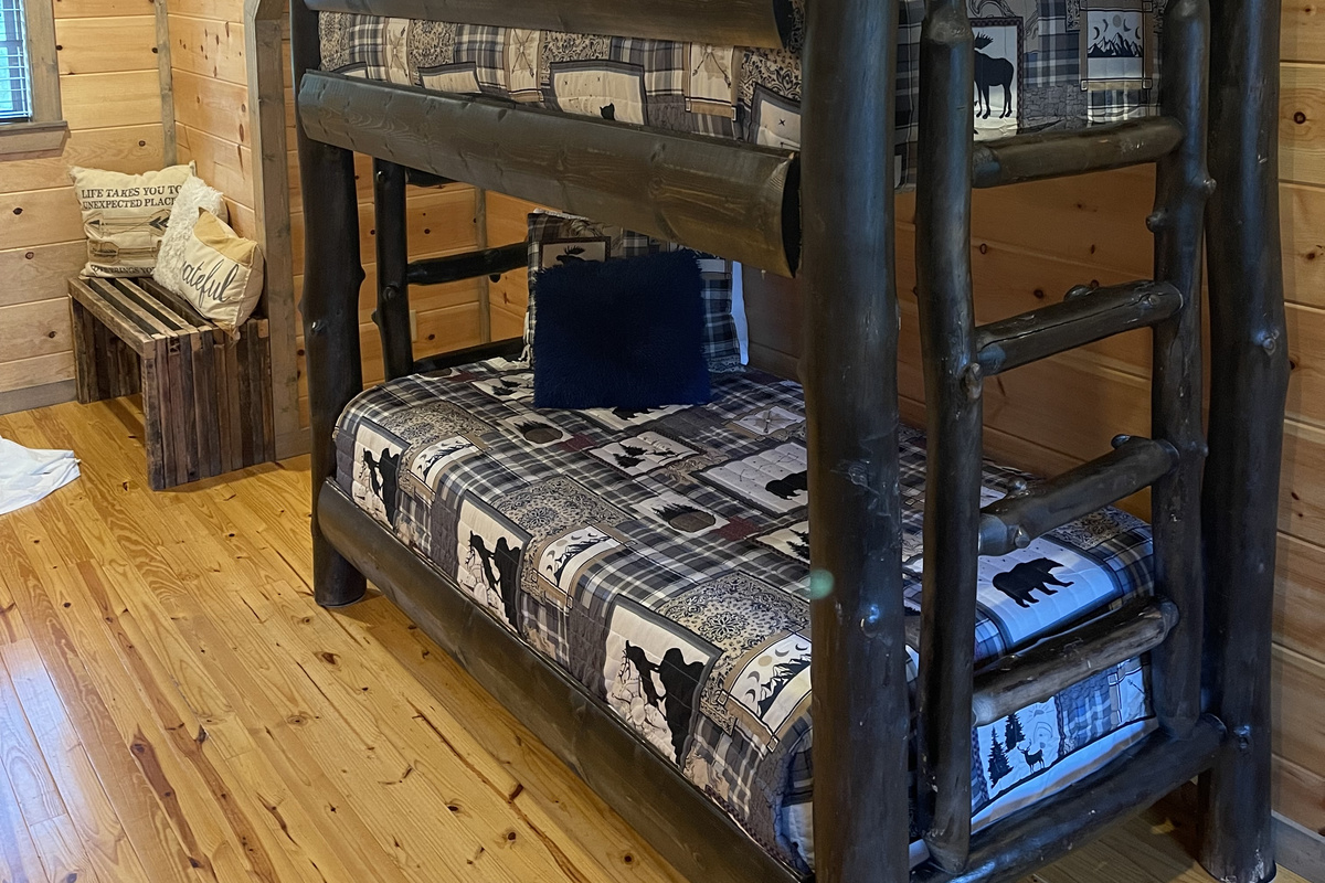The upstairs loft area with twin bunk beds and a throw-back game console table.