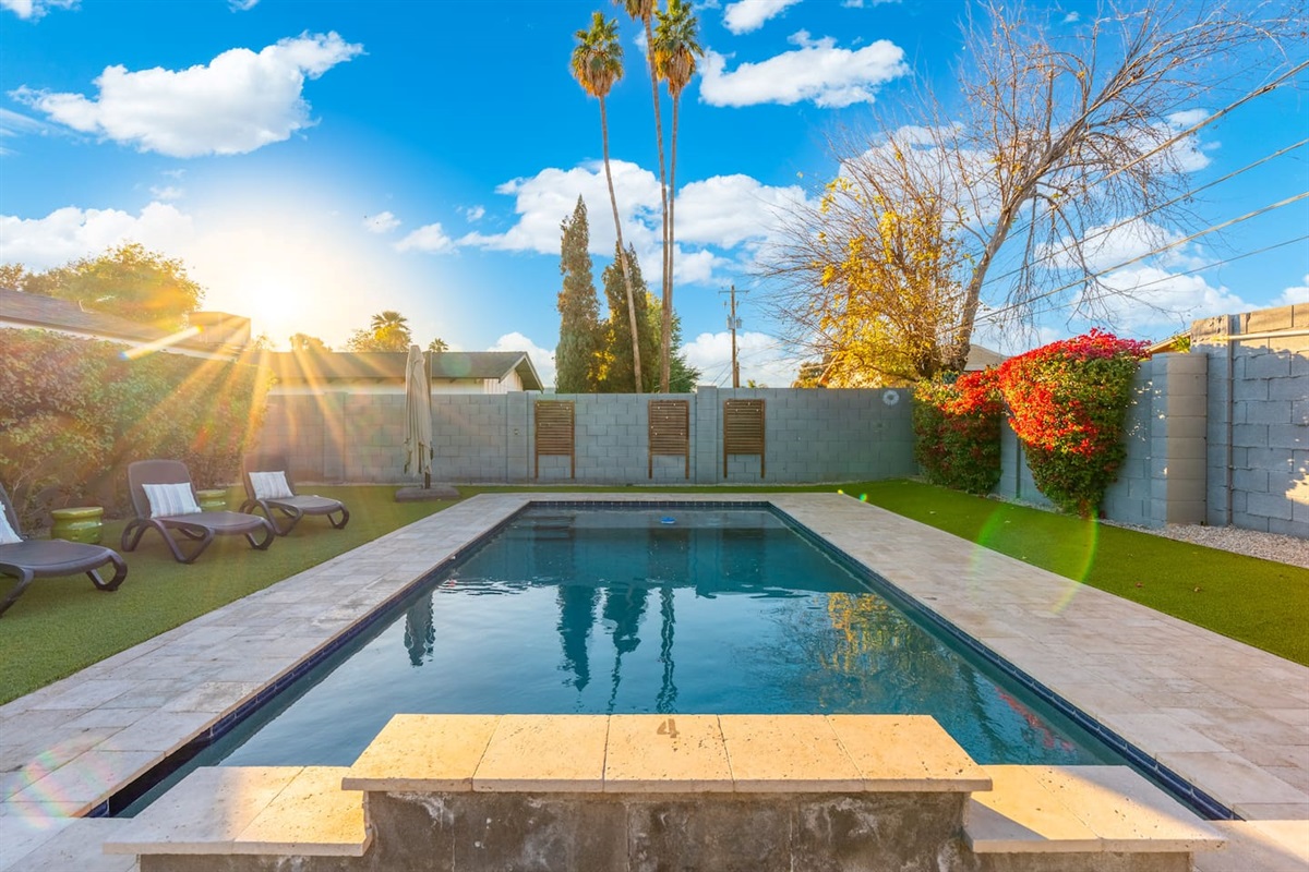 Bright sunlight streaming through the pool, creating shimmering reflections on the water and enhancing the serene atmosphere.