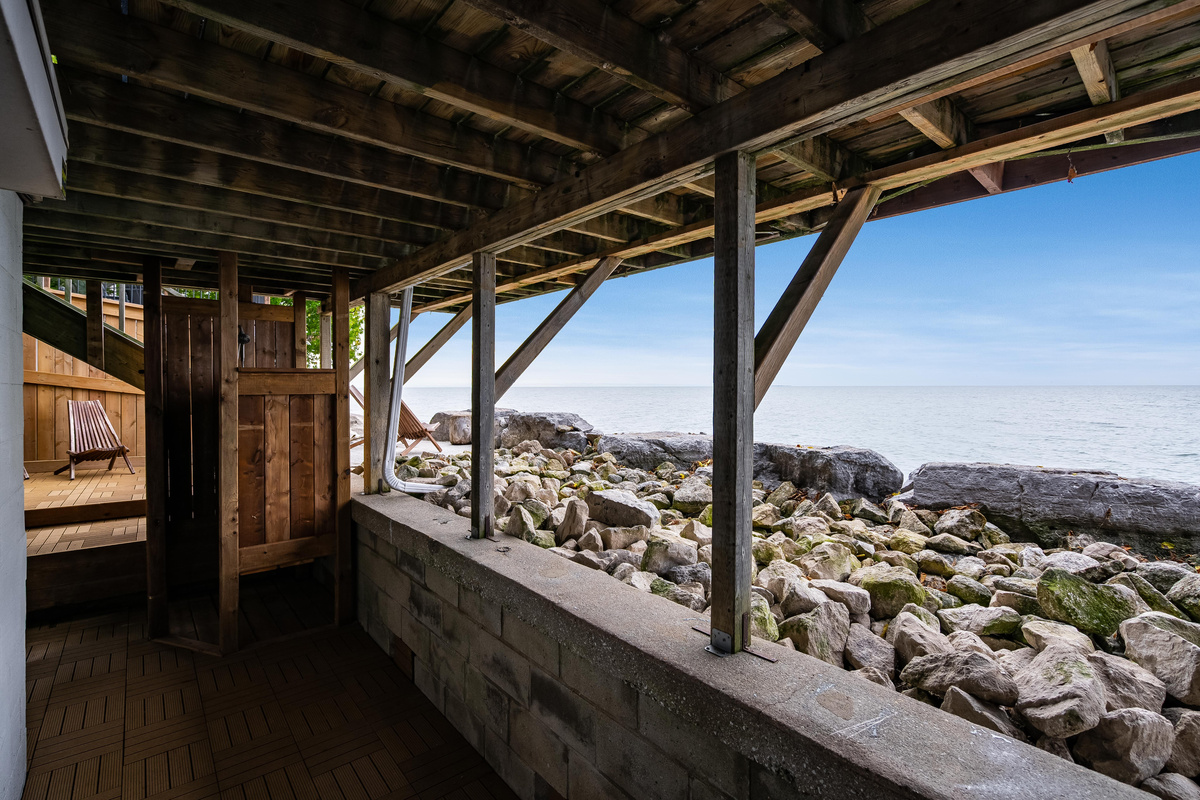 Covered outdoor deck with exposed timber beams and beautiful waterfront views.