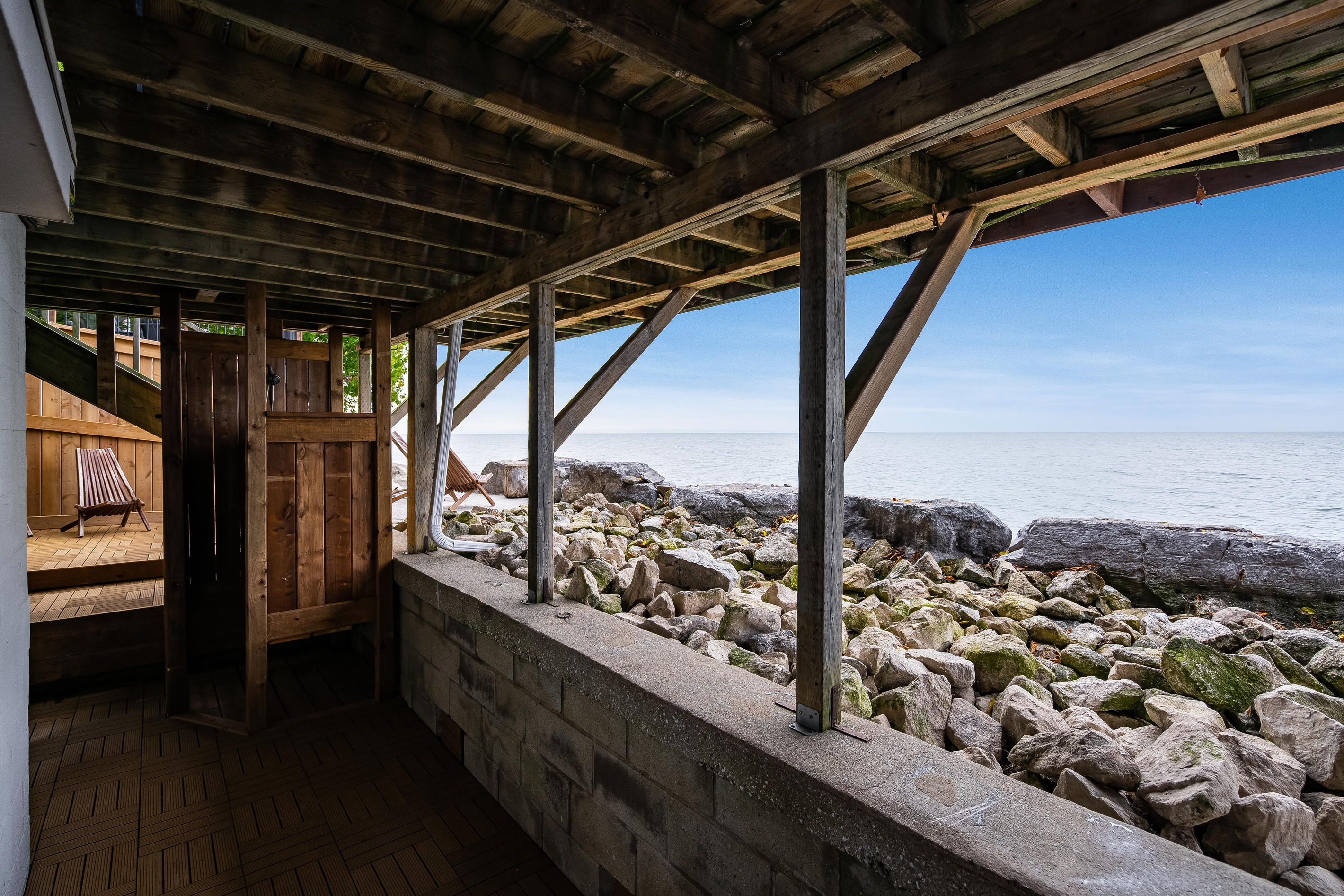 Covered outdoor deck with exposed timber beams and beautiful waterfront views.