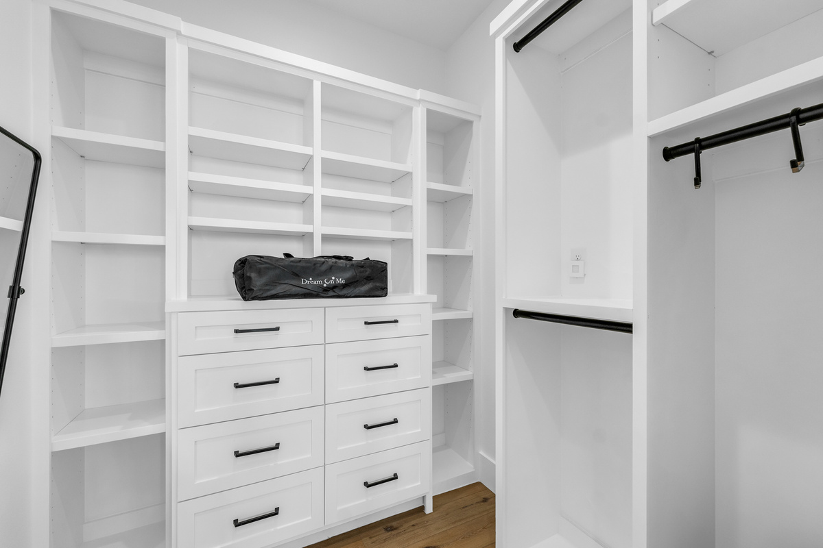 Cair Paravel: Custom white built-ins, open shelving, drawers, pack n play, and hanging rods, offer generous storage for an extended beach getaway.