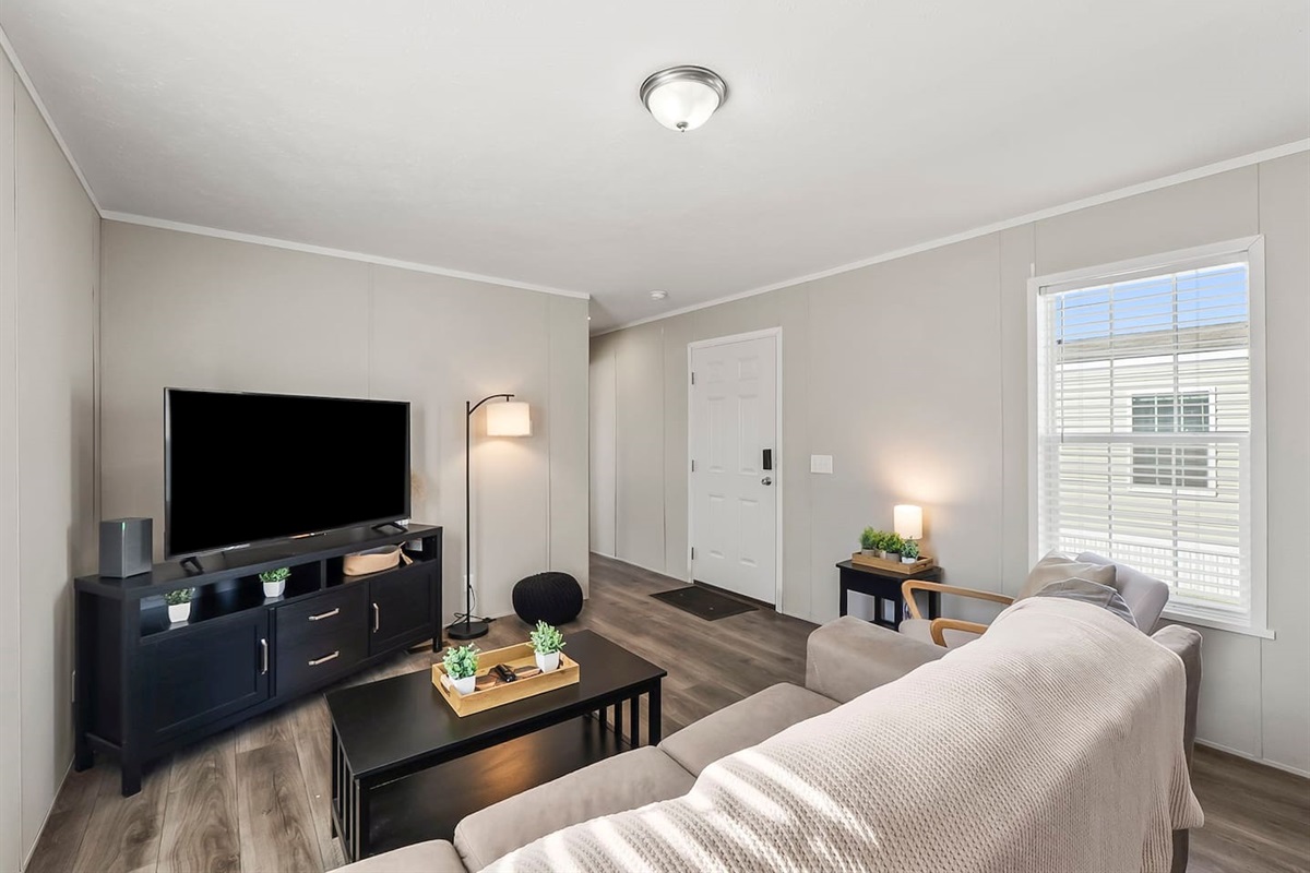 Clean and inviting living space with modern touches, smart TV, and easy access to the rest of the home.