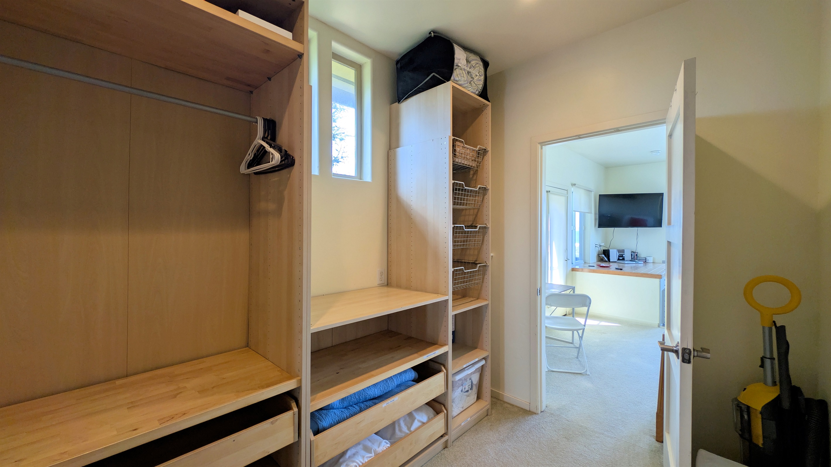 walk in closet in primary bedroom, a place for your suitcases and hanging clothes.