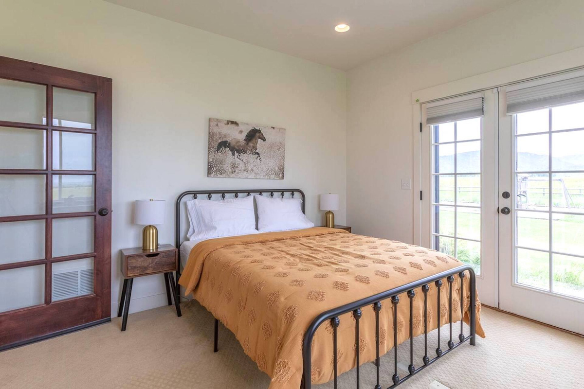 Bedroom 4: Queen bed with French doors opening to the backyard 
