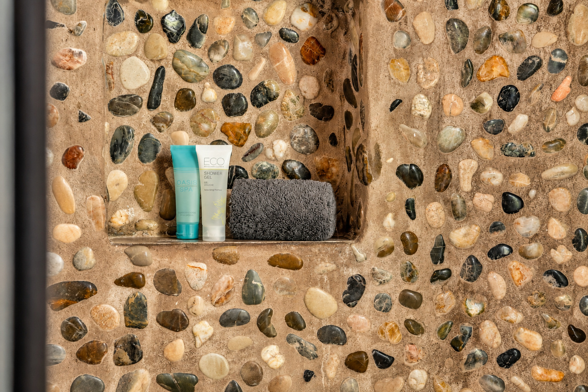 Tuck your toiletries into the river-rock niche and let the hot water roll.