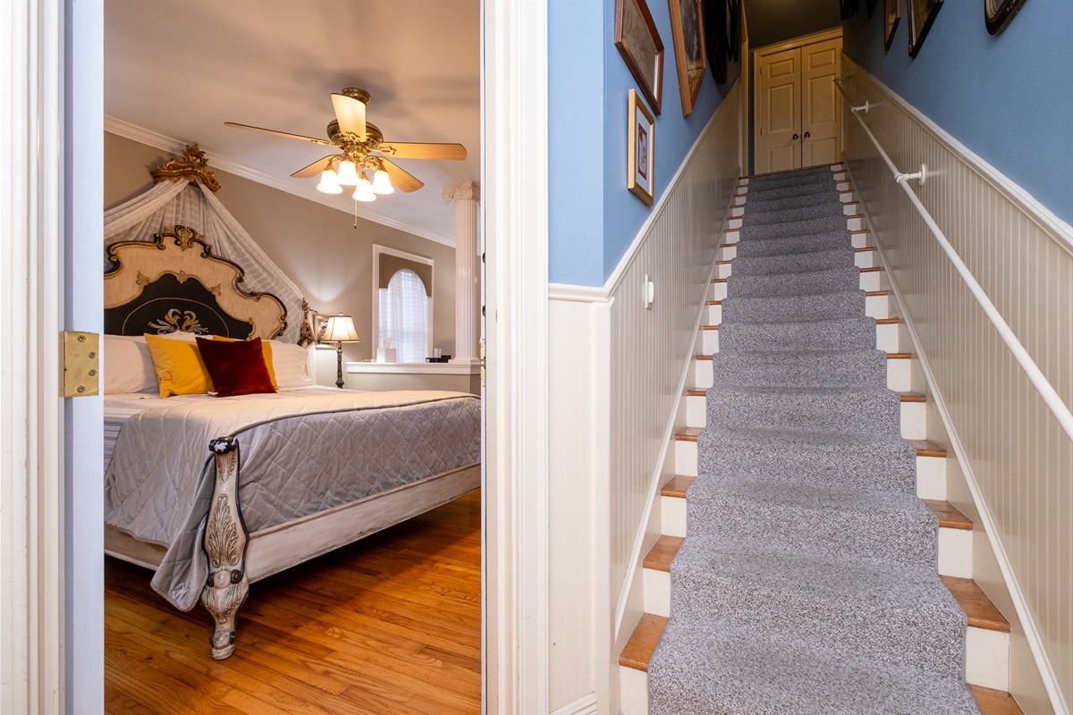 Private entry to the Majestic Spa Suite, with staircase access to the upper-level guest area featuring a communal coffee station, ice maker, microwave, small refrigerator, and seating.