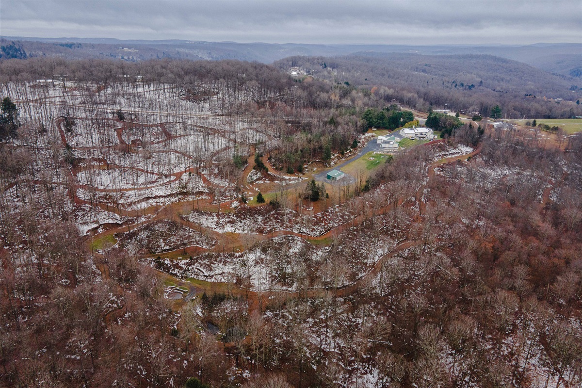 Aerial view of 23 private acres surrounded by peaceful mountain scenery.