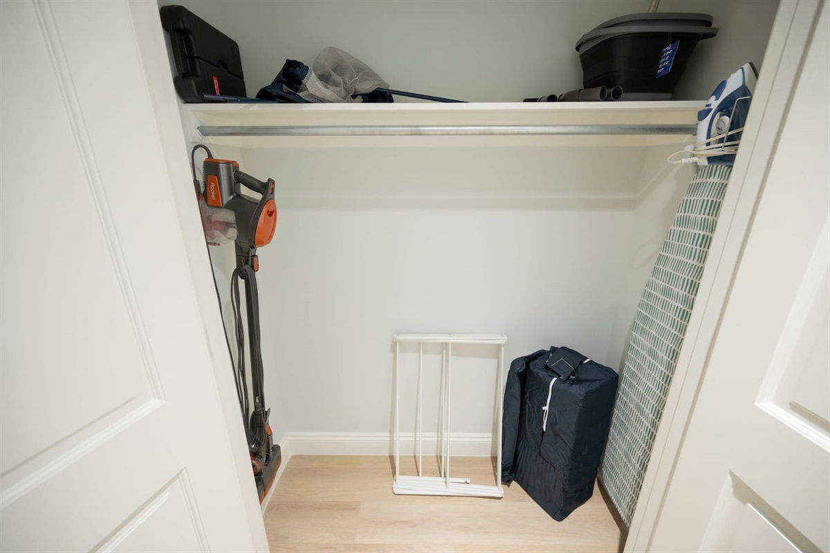 Neat closet storage with cleaning tools and bins for a tidy, organized home.