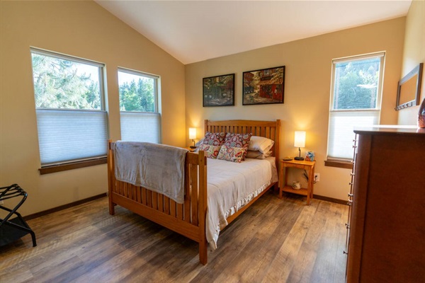 Master bedroom. Queen bed. TV.  Looks south down the valley and out to horse pasture.