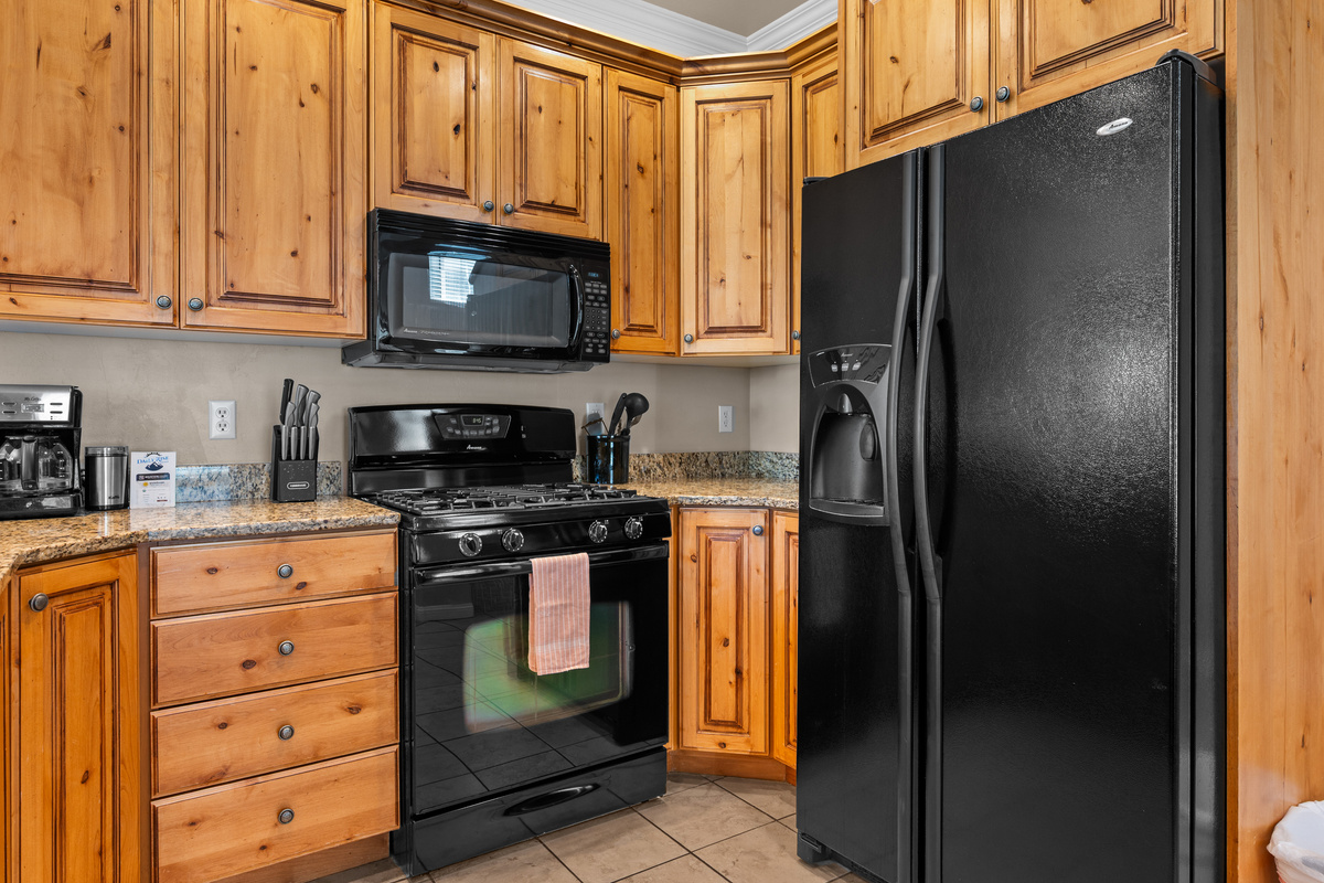 Well-stocked kitchen featuring a gas range, full-size refrigerator, microwave, and dishwasher.