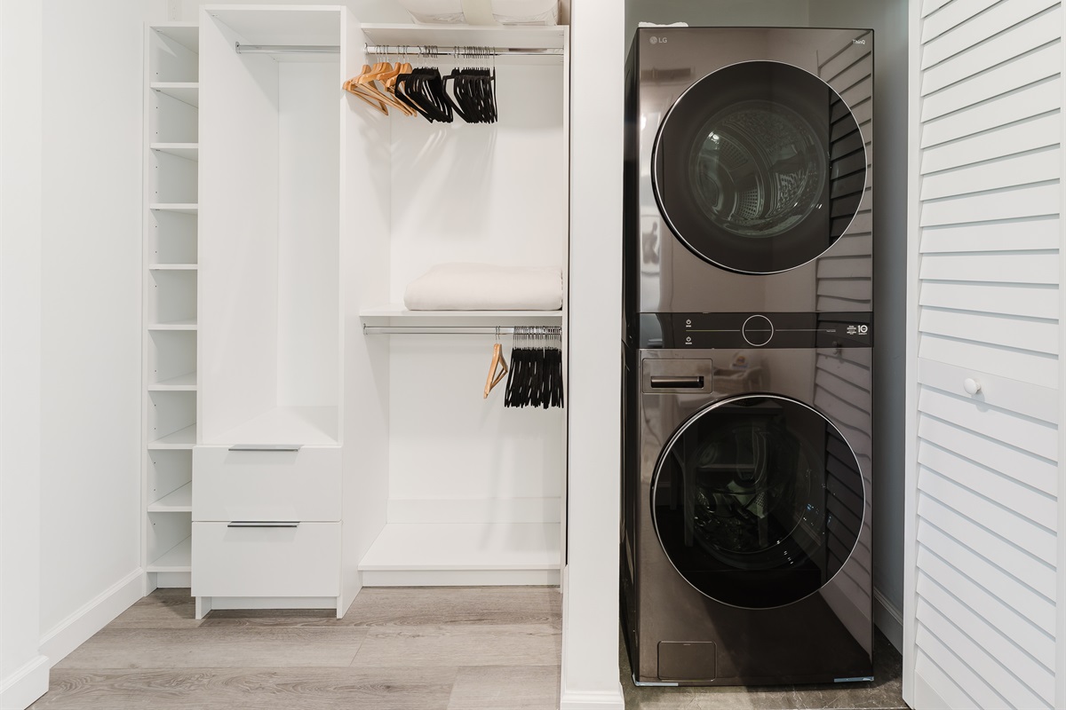 Spacious walk-in closet with built-in shelving, ample hanging space, and in-unit washer and dryer for ultimate convenience during your stay.
