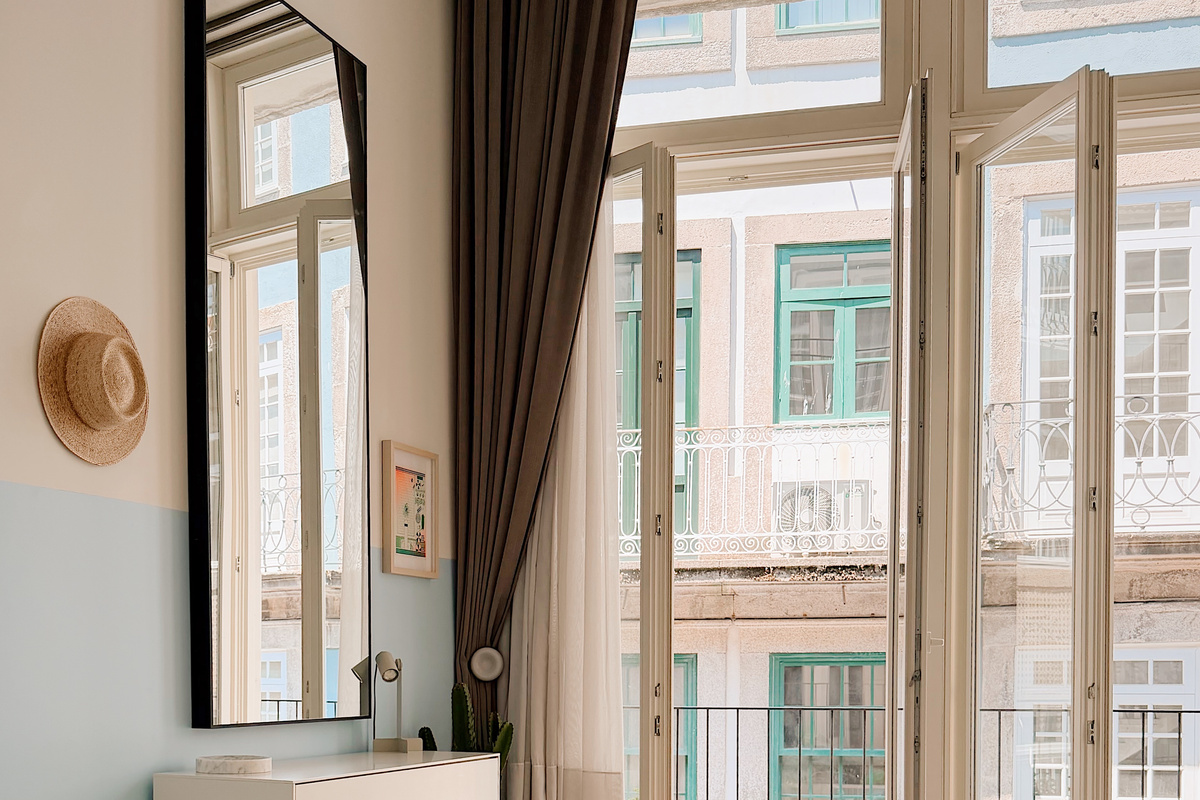 Balcony door open in the bedroom. Privacy sheers and dark curtains span the entire apartment.