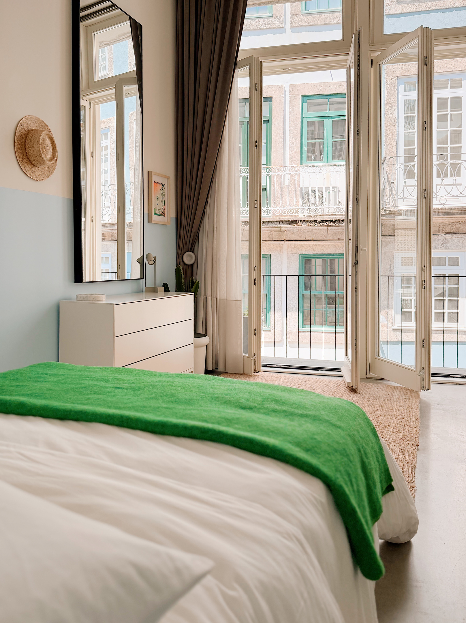 Balcony door open in the bedroom. Privacy sheers and dark curtains span the entire apartment.