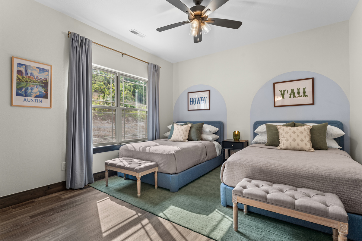 The Austin Twin Room has two full beds, with an Austin skyline print and 'Howdy, Y'all' Texas charm.