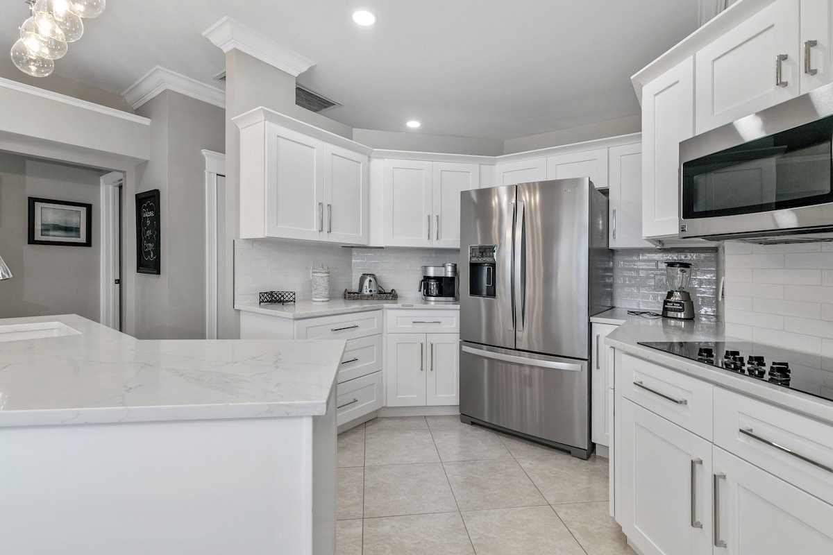 Sleek white kitchen with granite and stainless finishes