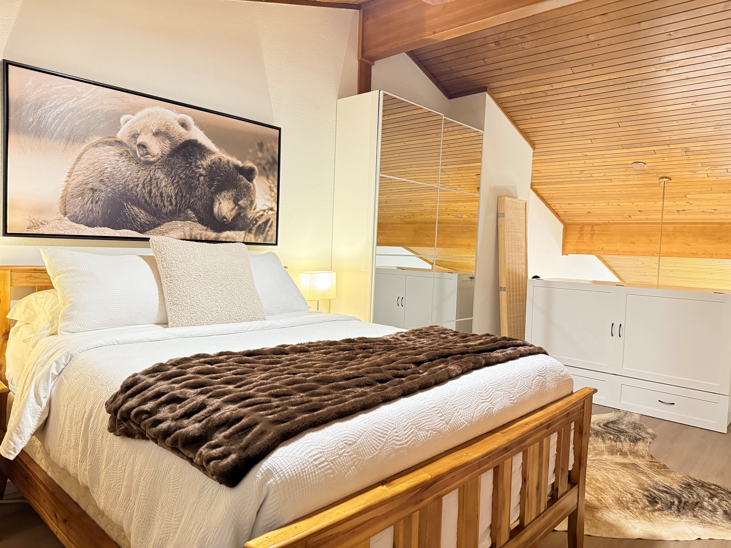 Upper Loft Bedroom: A bright, private bedroom suite with a cozy queen bed, excellent natural light, and convenient access to an en-suite bathroom and closet storage.