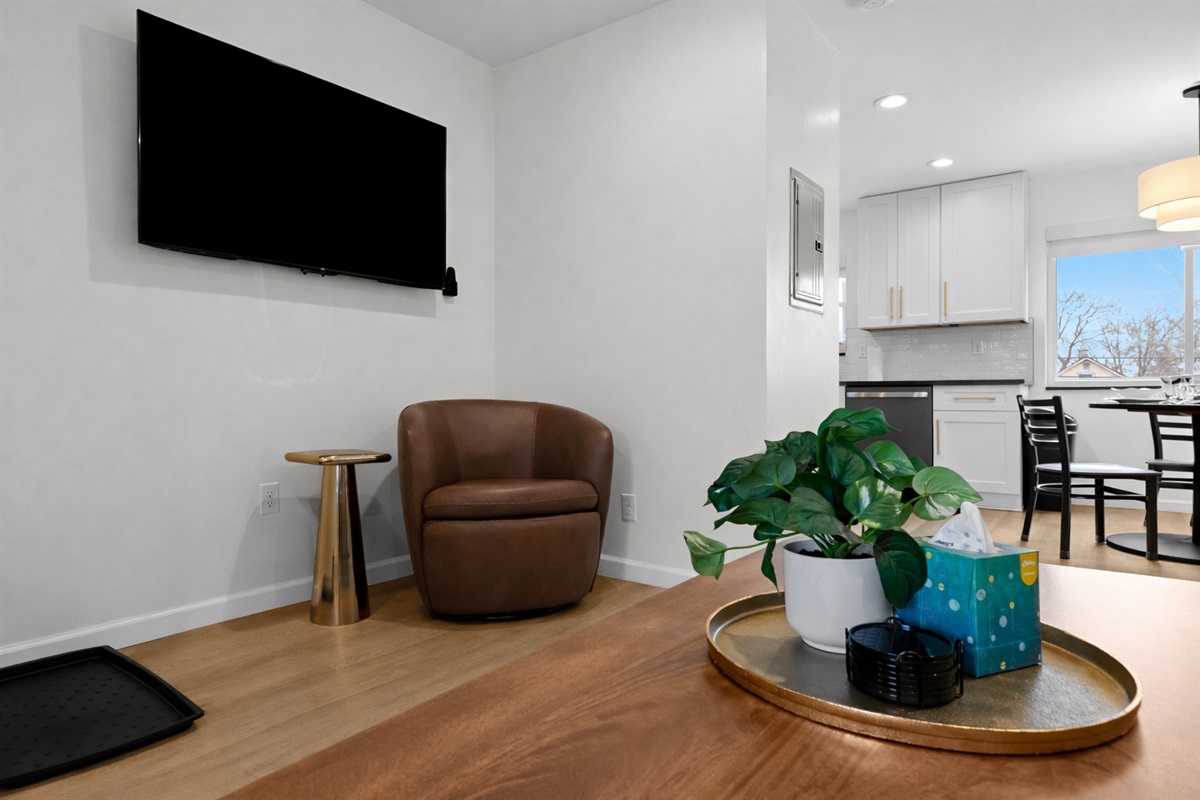 Relax in this stylish living area with cozy accent seating, smart TV, and an open layout that flows seamlessly into the kitchen and dining space.