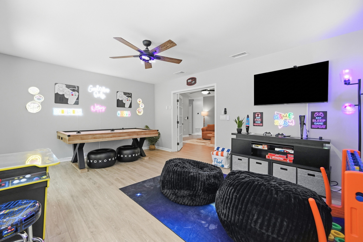 The game room is packed with entertainment, including air hockey, an arcade game, and giant Connect Four.