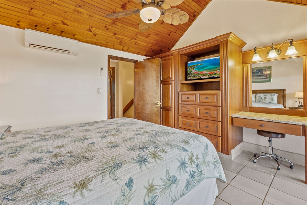 Primary bedroom with Queen bed, ceiling fan, TV and balcony