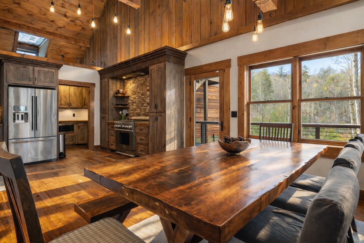 The dining area offers a spacious table and beautiful natural light.