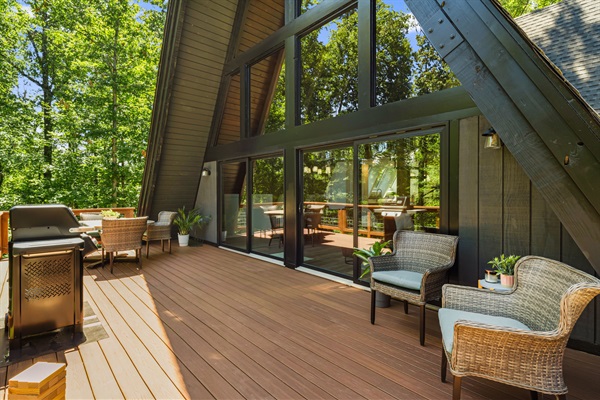Spacious main deck with a dining table that sits 6 people and a gas grill, all overlooking the backyard and natural area.