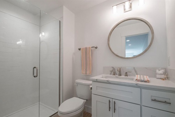 A thoughtfully designed shared full bathroom conveniently located next to the stairway downstairs for easy access.