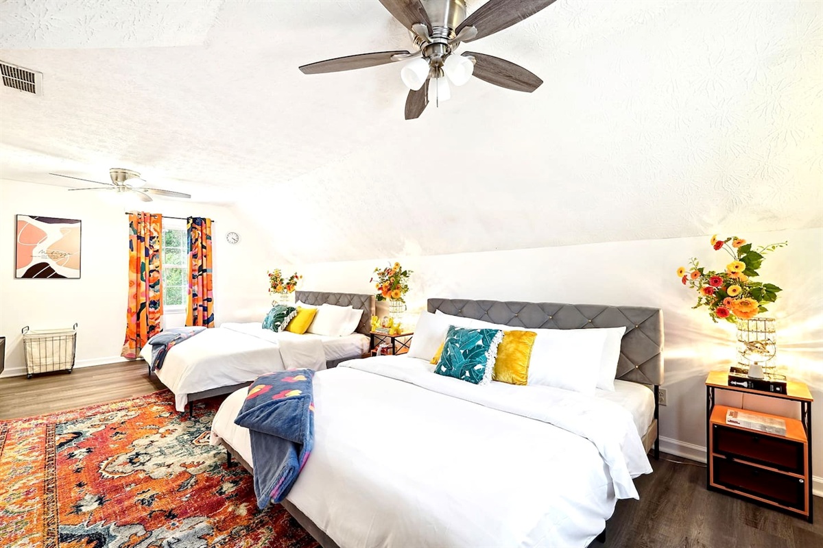 Bedroom 2 is located upstairs and features two king beds and a TV. This room does not have a private en-suite bathroom but has access to a shared full bathroom on the second floor.