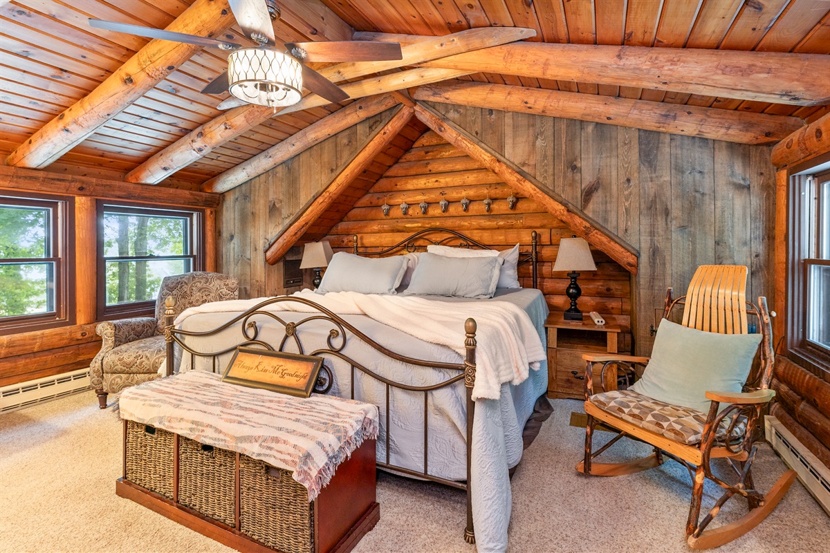 Bedroom #1 Rustic charm meets comfort in this cozy log cabin Master bedroom, featuring a king bed, vaulted ceilings with exposed beams, and serene woodland views. Ensuite bathroom 