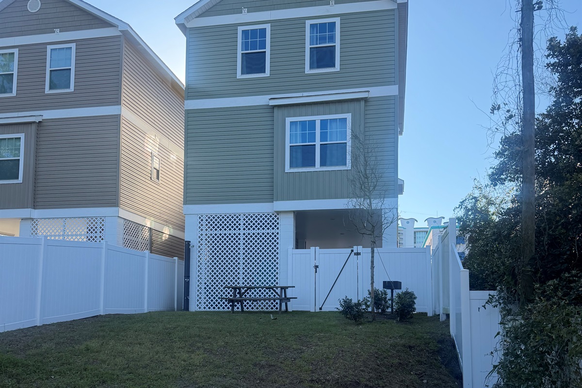 Fenced in back yard with grill and outdoor shower