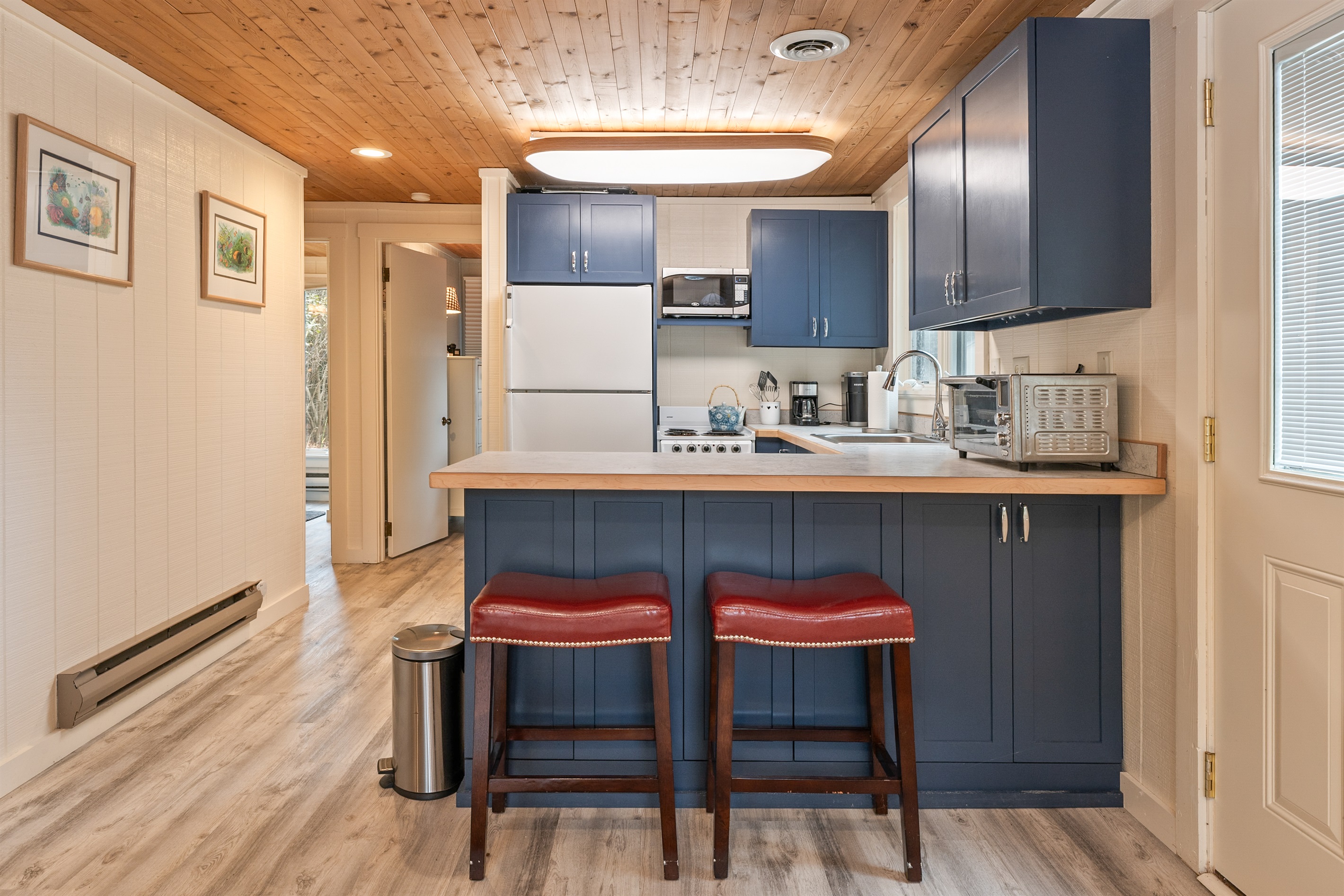 Fully equipped kitchen with bar seating and stainless appliances.