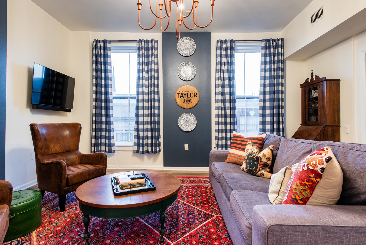 The EH Taylor Suite living room, with a sofa, leather chair and patterned rug.