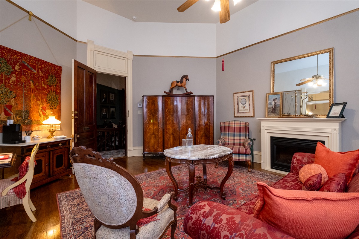 Additional view of the suite highlighting period artwork, seating, and original fireplace.