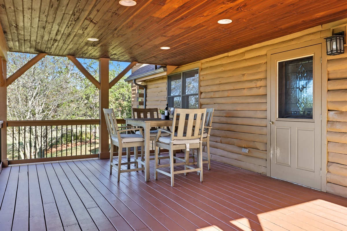 Covered deck dining area with serene views.