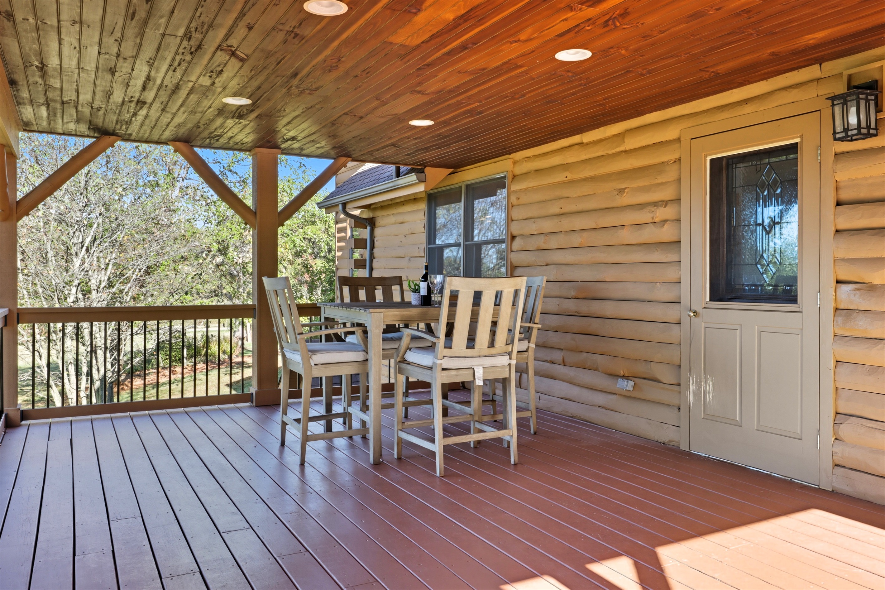 Covered deck dining area with serene views.