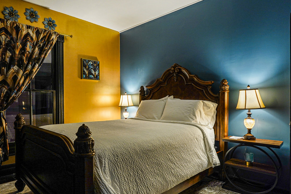 Art Deco bedroom with gold metallic wall, curtains and decor. Electric candles for a romantic evening.