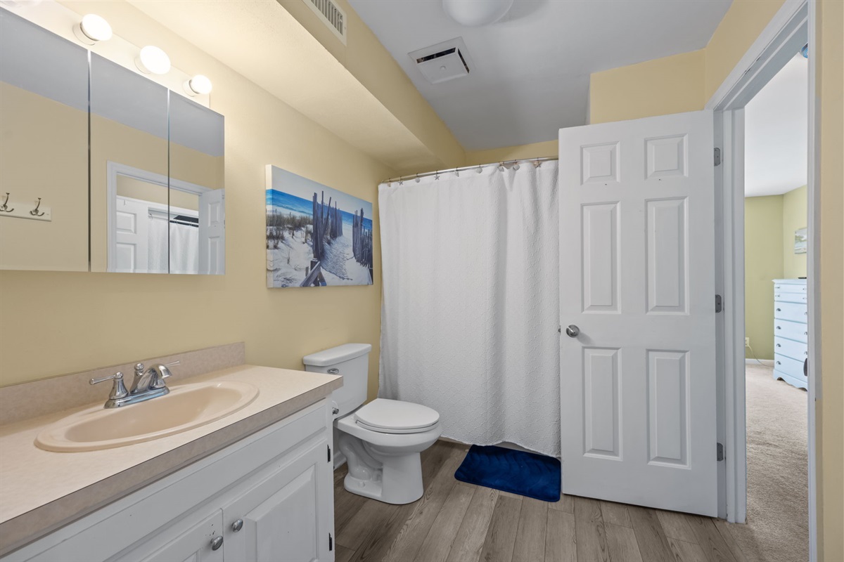 Clean and bright full bathroom with a shower tub combo and plenty of space to get ready for the day
