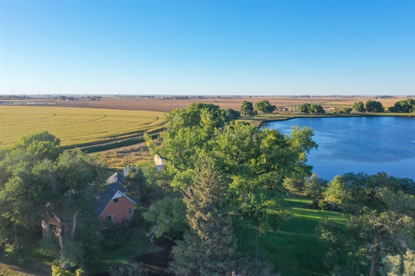 The property sits harmoniously in the landscape, where farmland, water, and sky meet for a breathtaking view.