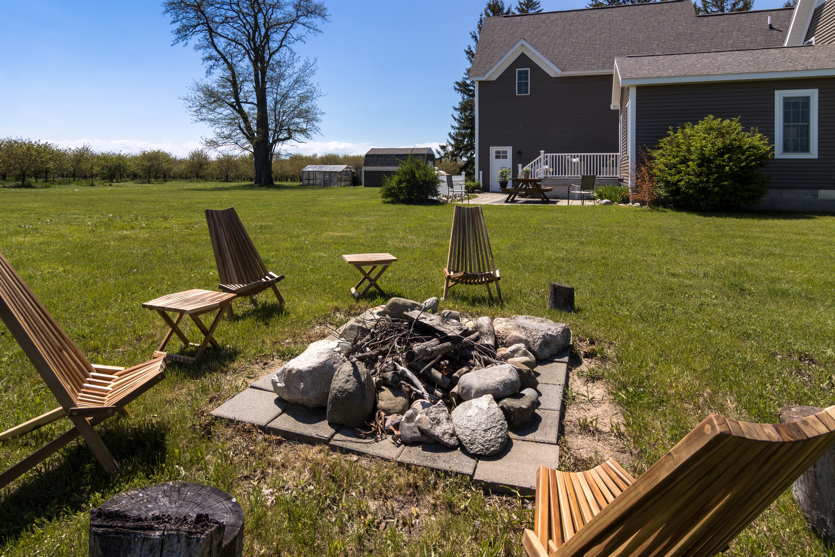 Circle of chairs around a wood-burning fire pit.