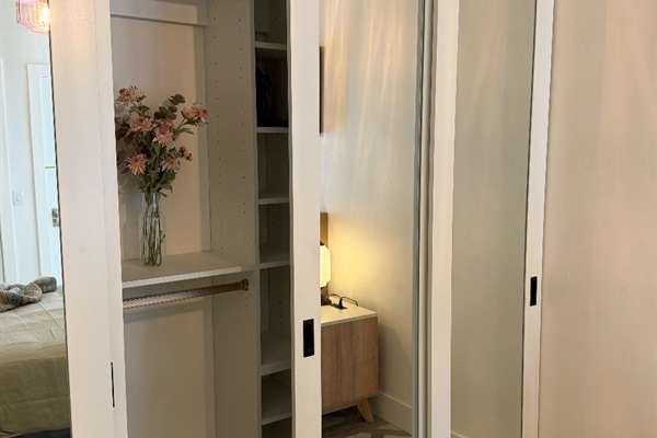 Closet with tons of drawers, hanging space, and laundry basket